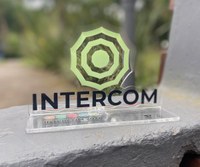 Troféu em acrílico transparente com logomarca em forma de teia de aranha na cor verde claro, e nome "Intercom 2024", na cor preta. Foto: Agda Aquino